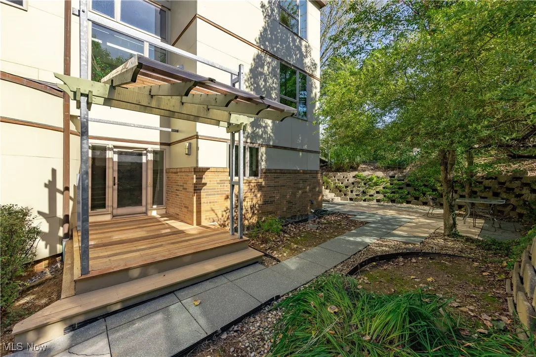 Property entrance with brick siding and a wooden deck
