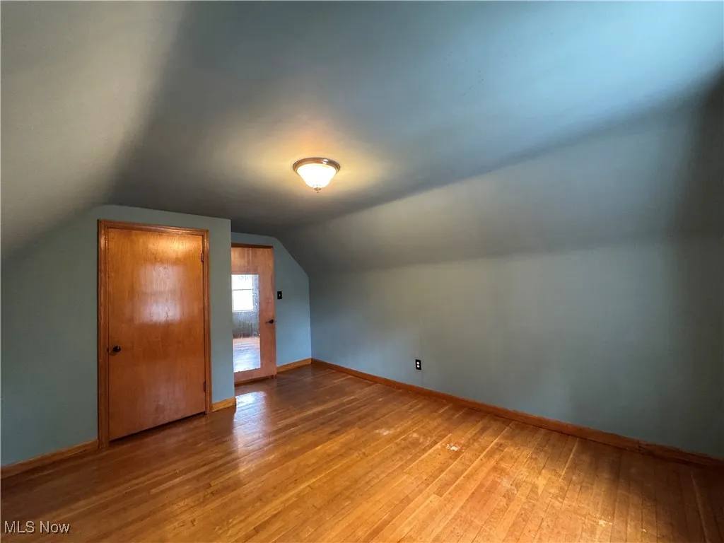 Bonus room featuring lofted ceiling and light wood-style flooring