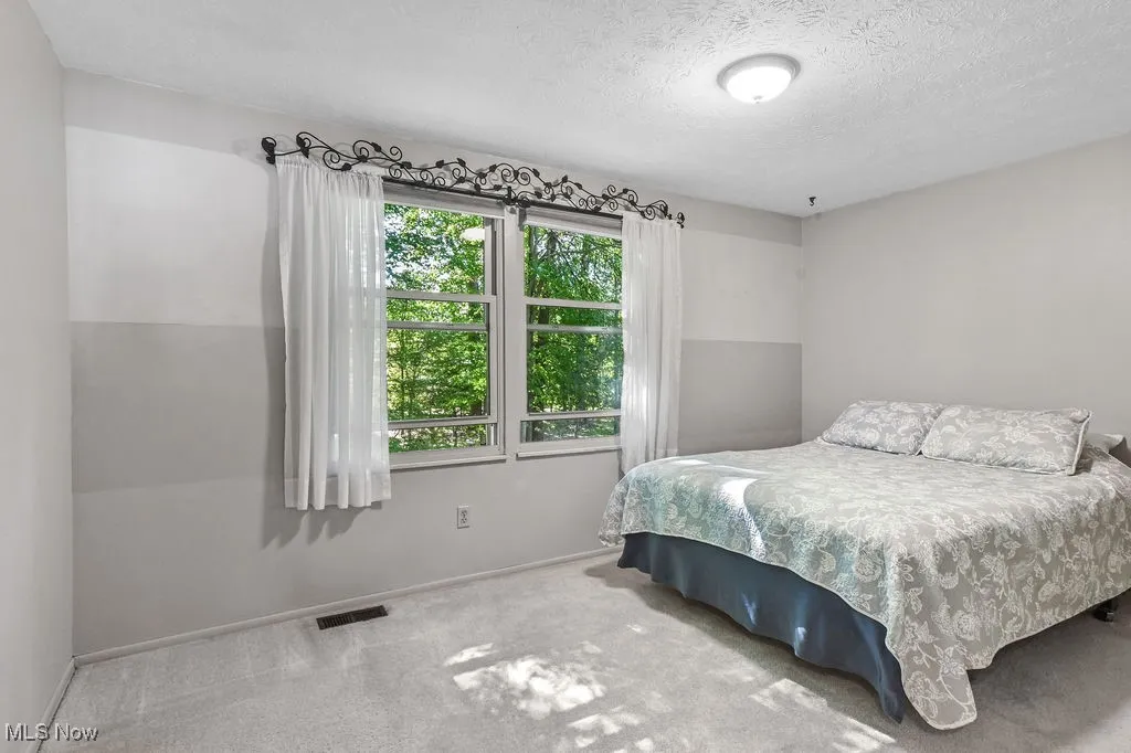 Bedroom with carpet and a textured ceiling