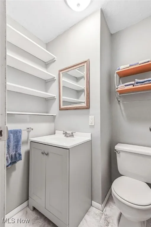 Half bathroom with vanity and baseboards