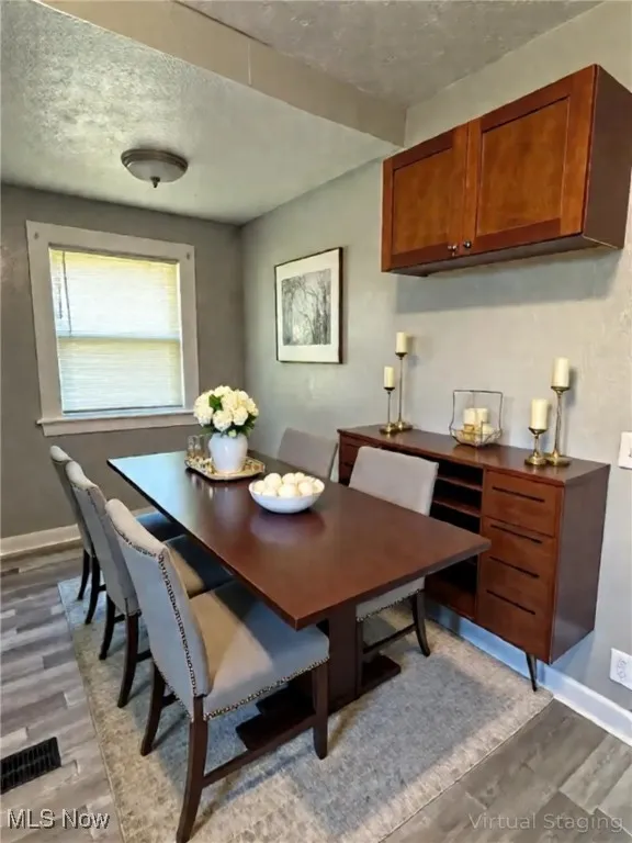Dining area featuring light wood finished floors and a textured ceiling