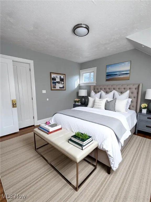 Bedroom featuring wood finished floors and a textured ceiling