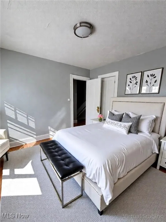 Bedroom featuring a textured ceiling and light wood finished floors