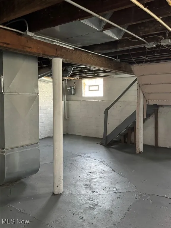 Below grade area featuring stairs and heating unit