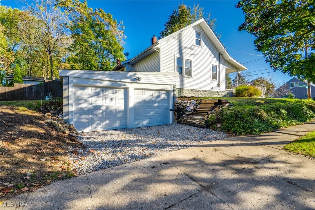 View of home's exterior with gravel driveway and a chimney