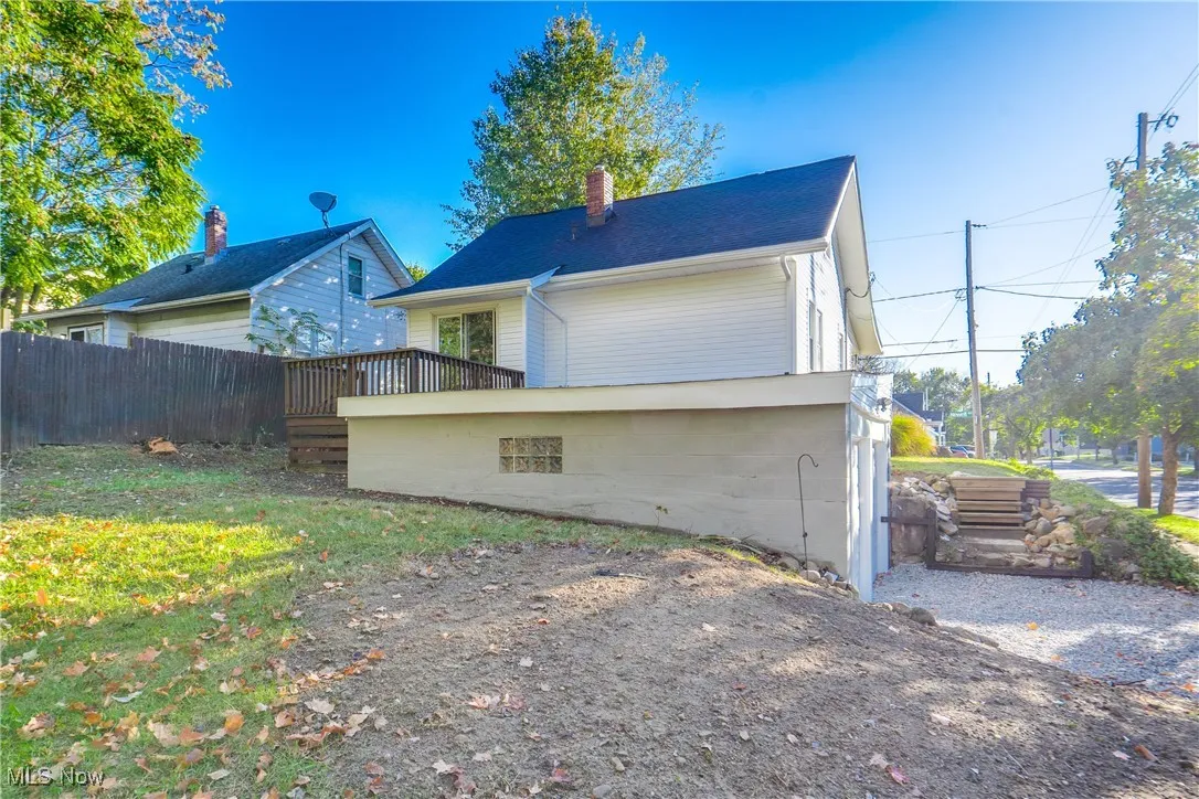 Back of house featuring a chimney and a wooden deck