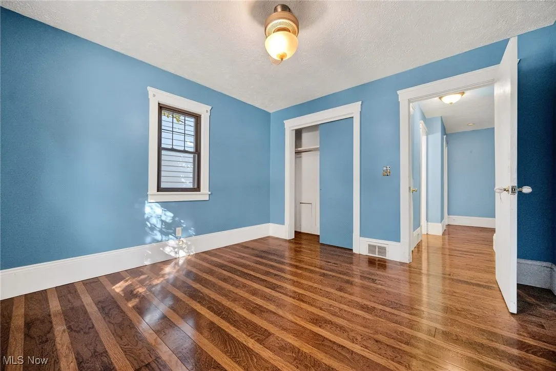 Unfurnished bedroom featuring a closet, dark wood-style flooring, and a textured ceiling