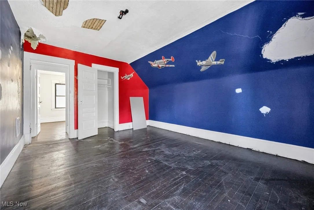 Bonus room featuring dark wood finished floors and baseboards