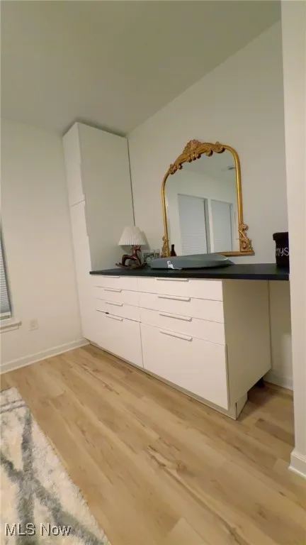 Room featuring vanity and light wood-style flooring