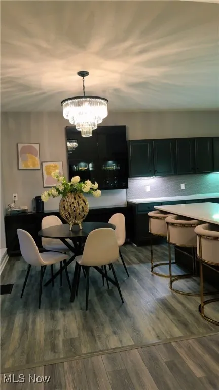 Dining room featuring dark wood-style flooring and a chandelier