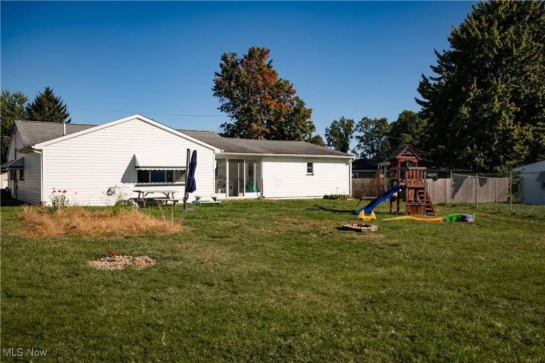 Rear view of property with a playground