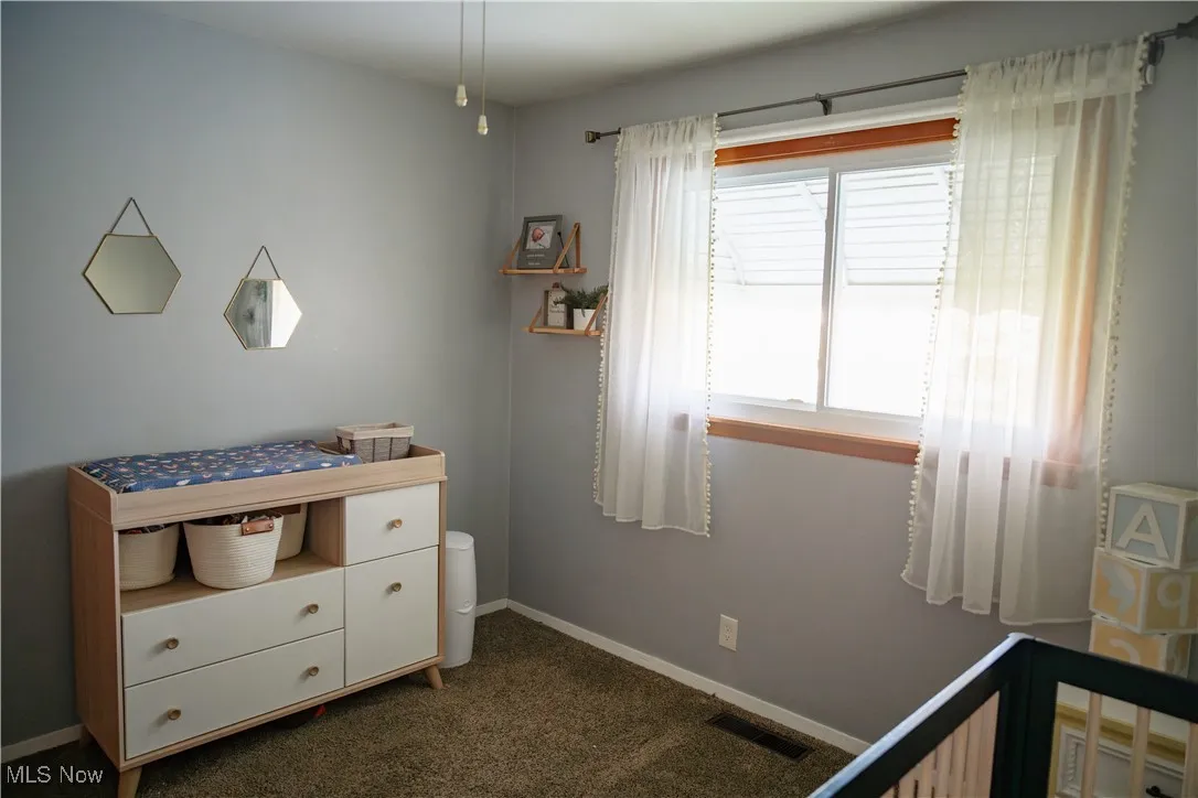 Bedroom with dark carpet and baseboards