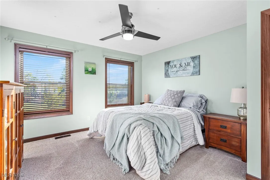 Carpeted bedroom with baseboards and a ceiling fan