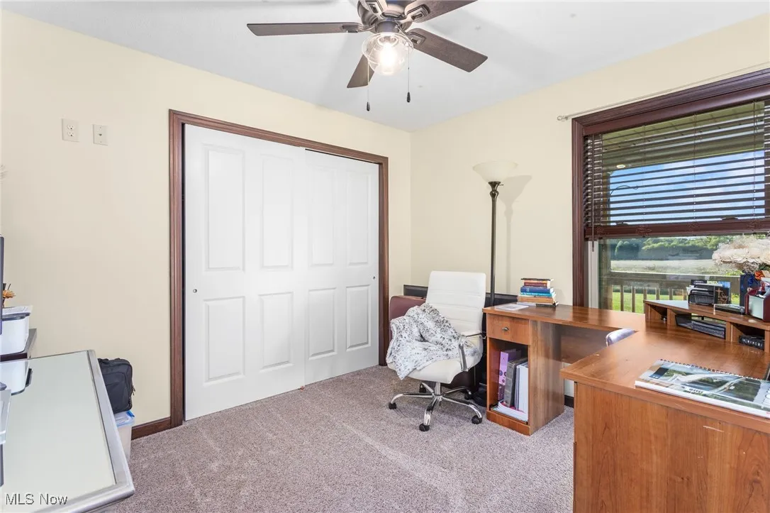 Office area with light carpet and ceiling fan