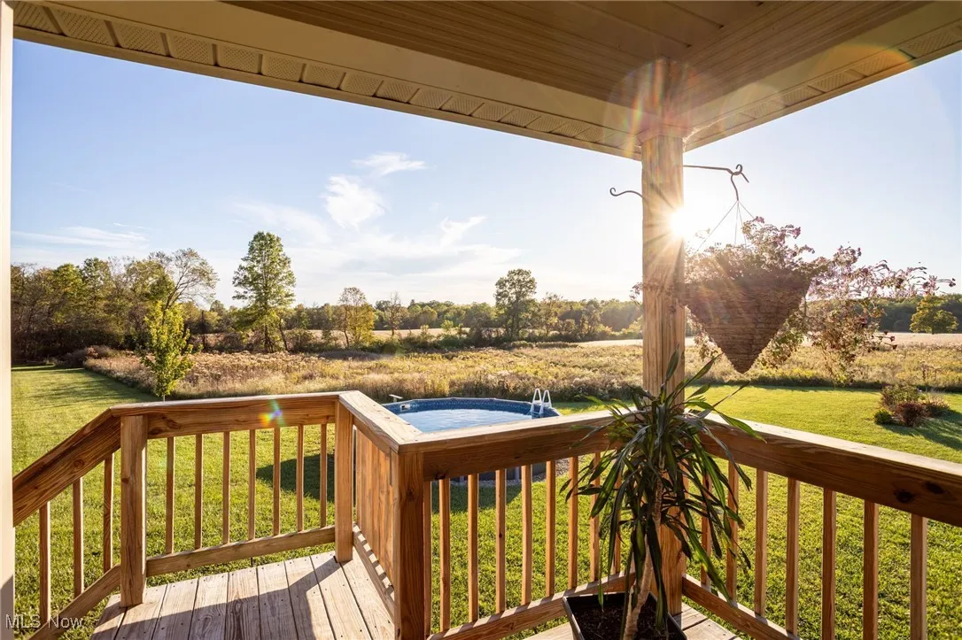 Wooden terrace featuring a yard