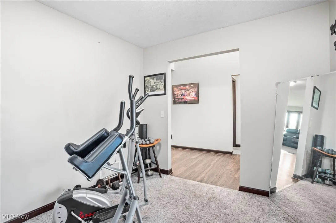 Workout room featuring carpet and baseboards