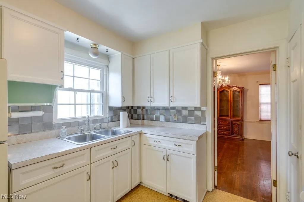 Kitchen featuring light countertops, white cabinetry, and decorative backsplash