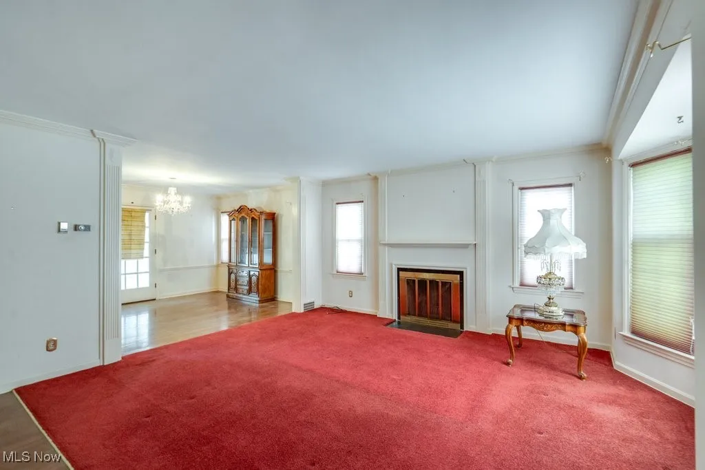 Living room featuring healthy amount of natural light, a fireplace with flush hearth, and carpet