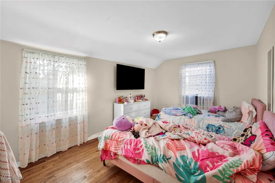 Bedroom with light wood-style flooring and vaulted ceiling