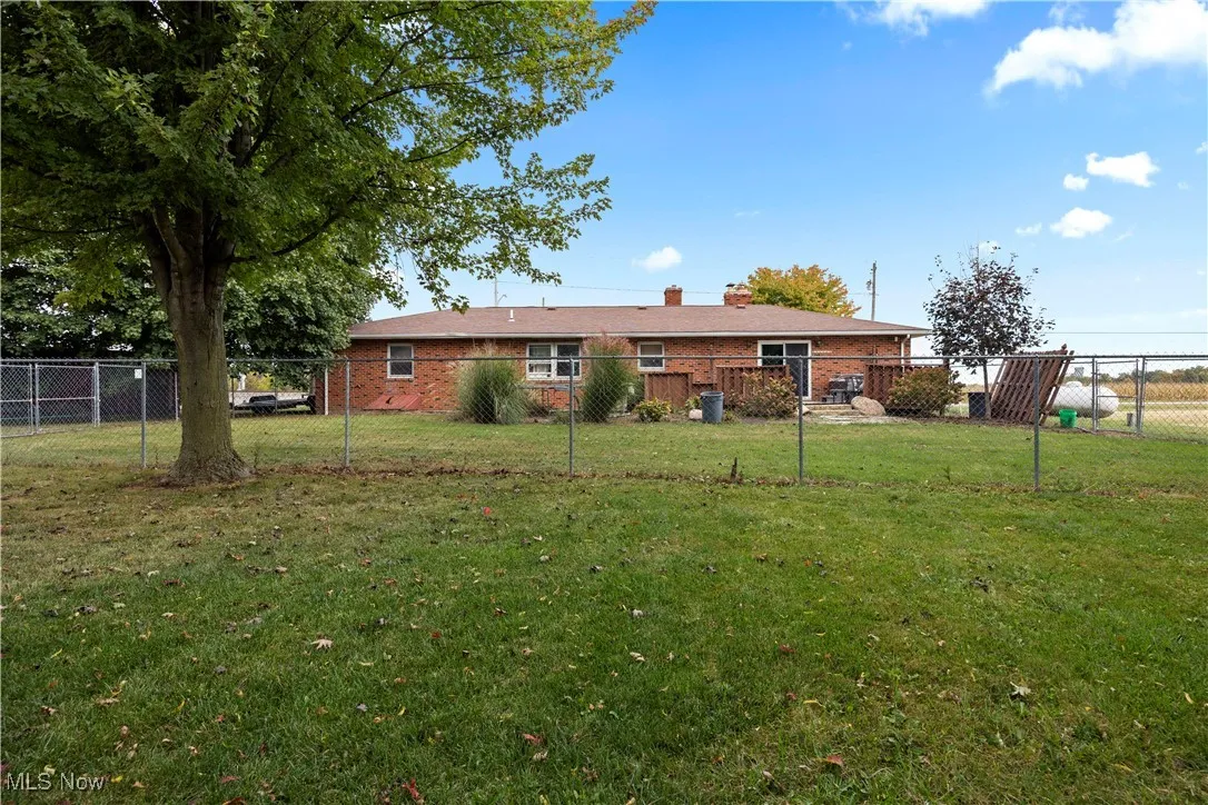 Back of property with a chimney and brick siding
