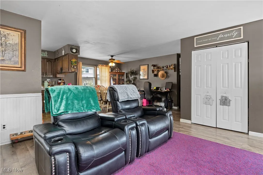Living area featuring light wood finished floors and a ceiling fan