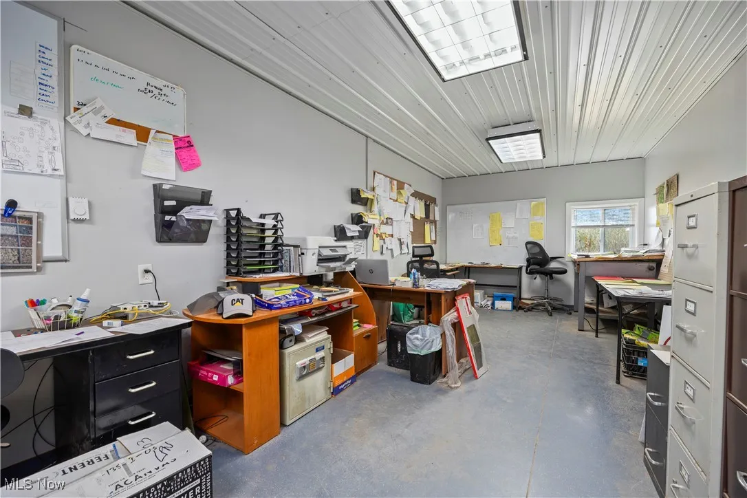Misc room featuring a desk and finished concrete flooring