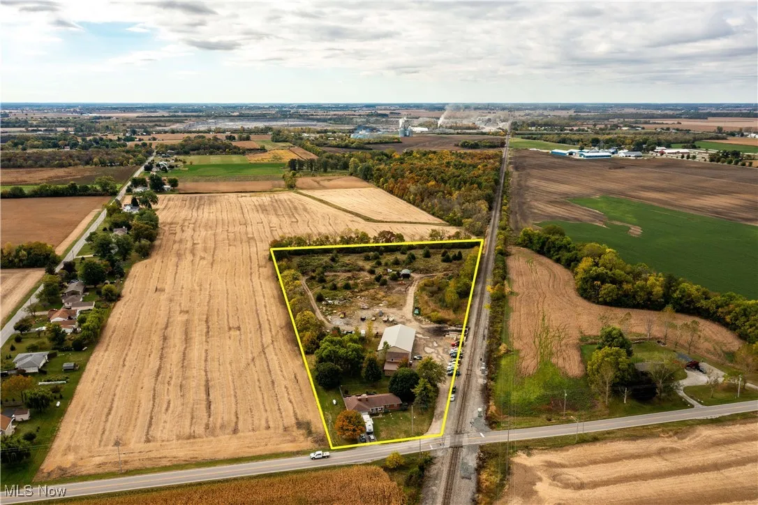 Aerial view of sparsely populated area featuring property parcel outlined and farmland
