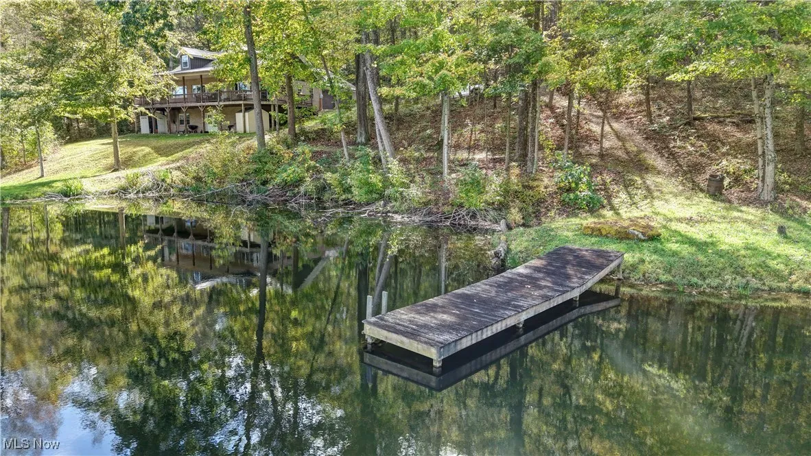 Dock area featuring a water view and a forest view