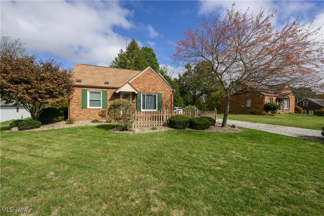 Ranch-style house with a front yard, brick siding, and roof with shingles
