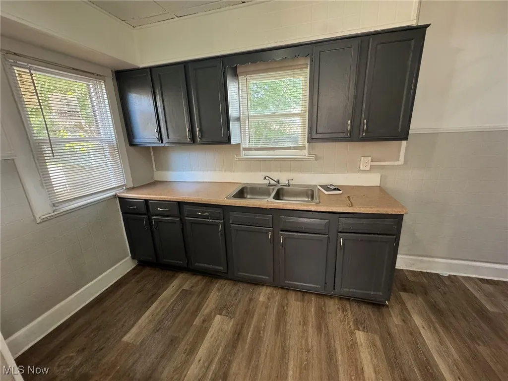 Kitchen featuring light countertops, dark wood finished floors, and a wainscoted wall