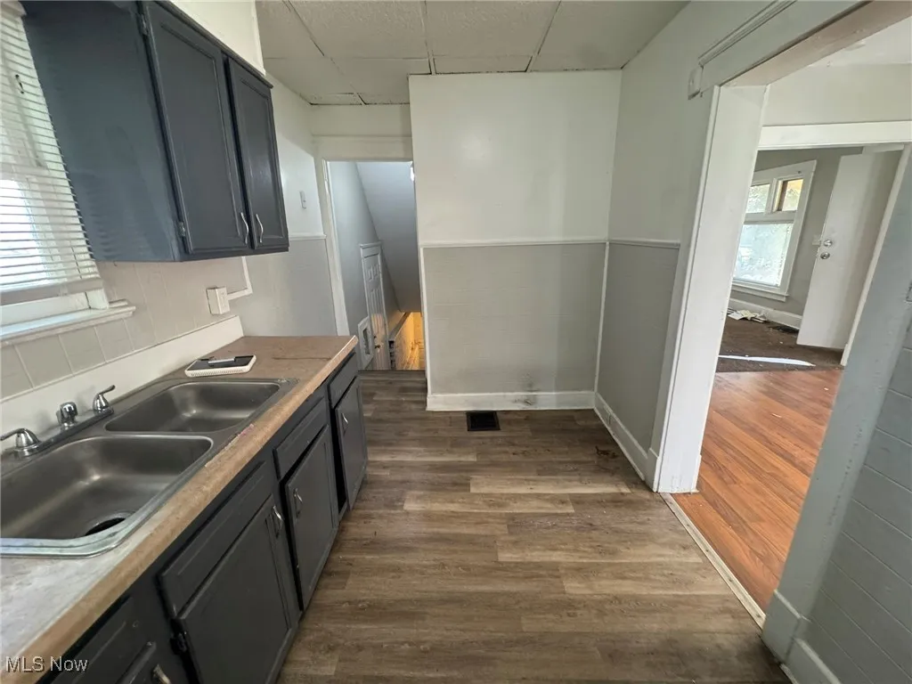 Kitchen featuring a paneled ceiling, dark wood-type flooring, and light countertops