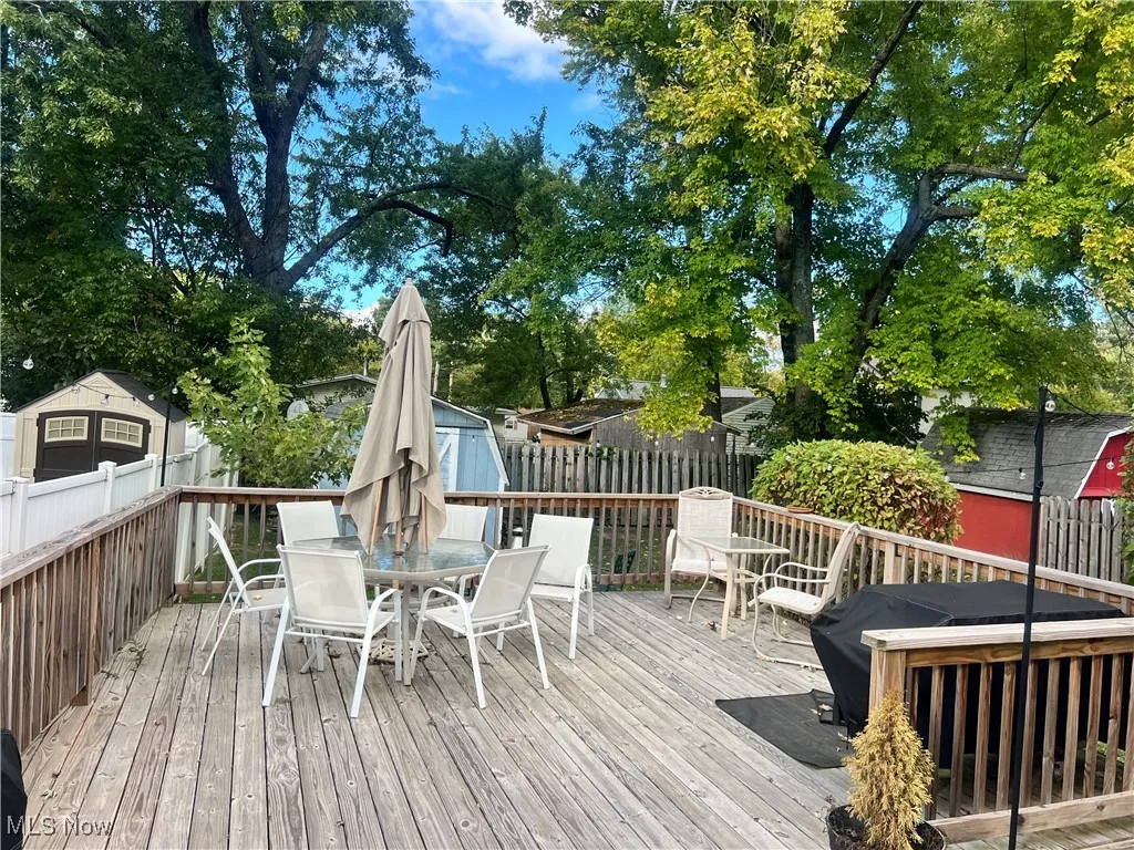 Wooden deck featuring outdoor dining area and a fenced backyard