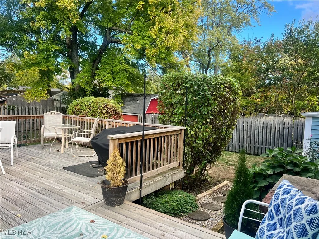 Wooden terrace with a fenced backyard and outdoor dining space