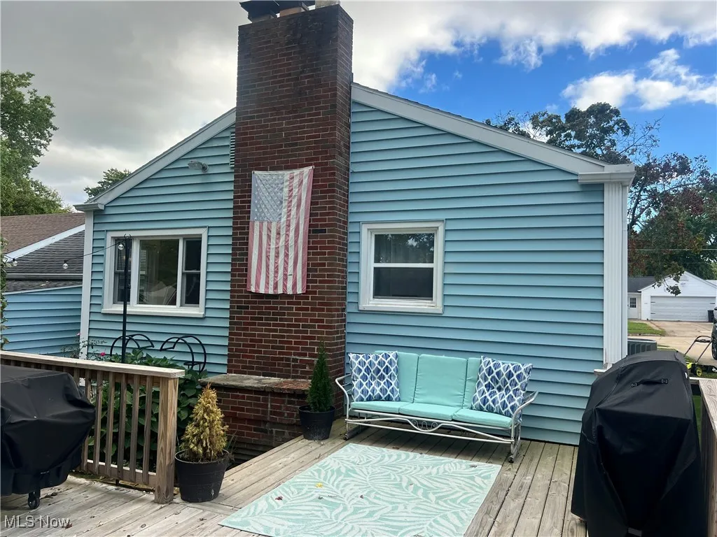 Back of property featuring a wooden deck and a chimney