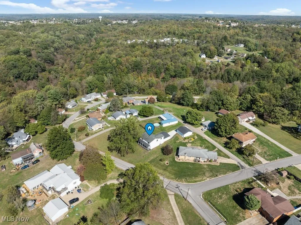 View of property location featuring nearby suburban area and a forest
