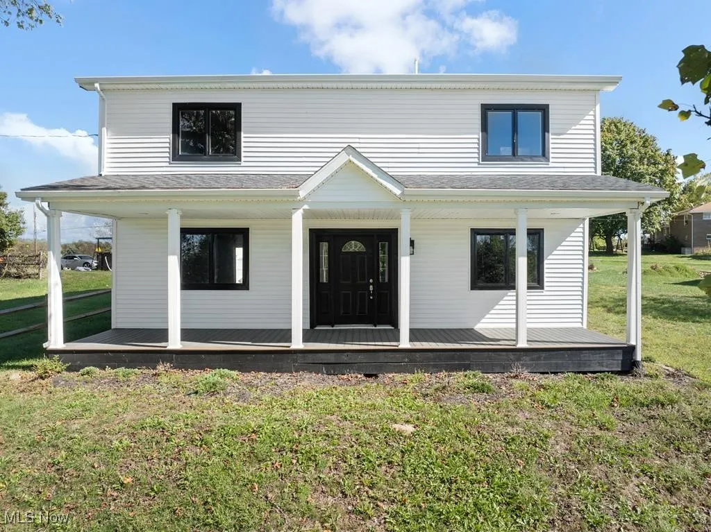 Farmhouse inspired home featuring a porch and a front yard