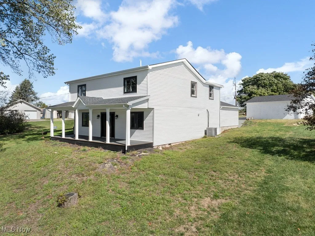 Back of property with a yard and a porch