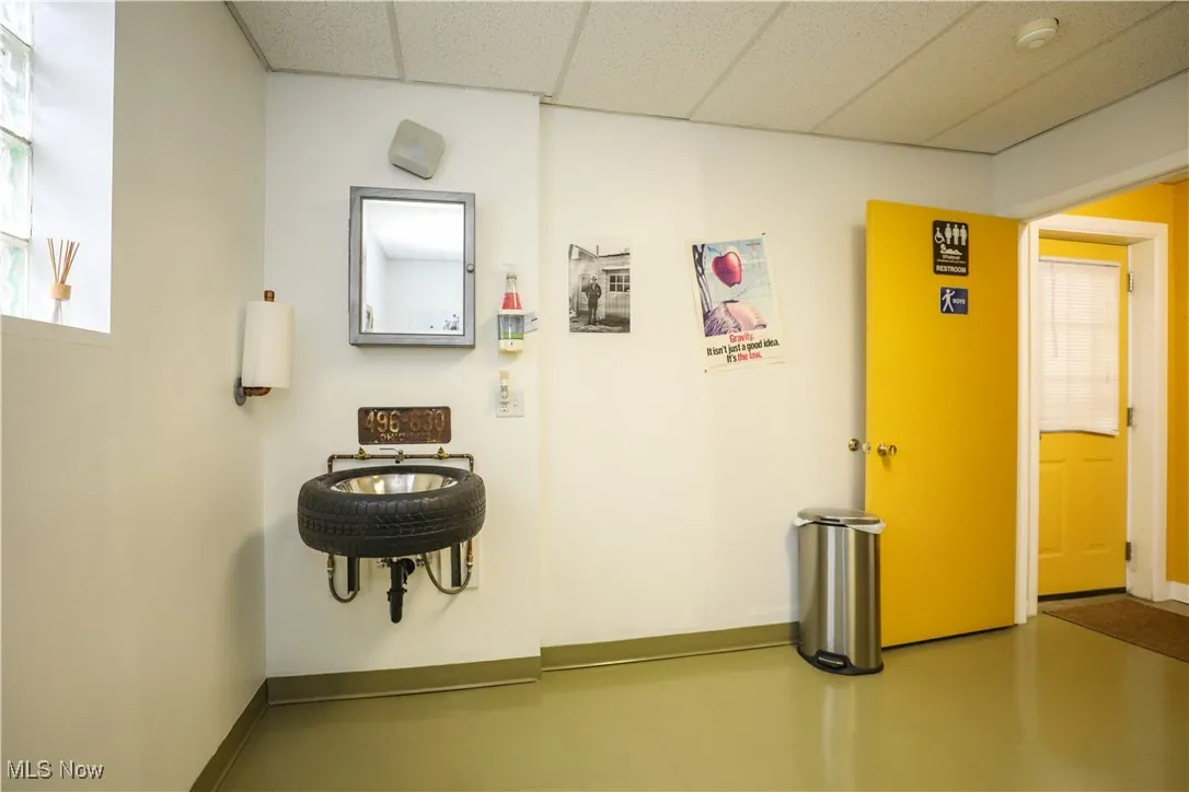 Corridor with a paneled ceiling and baseboards