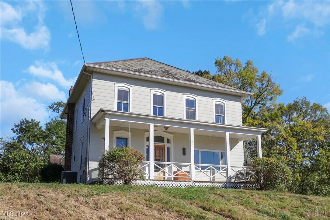 View of front of house with covered porch and a front yard