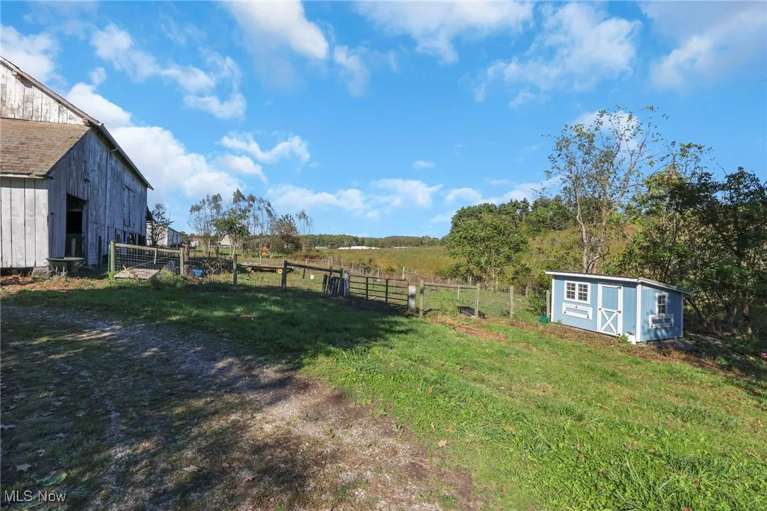 View of yard with a shed, a rural view, and a barn