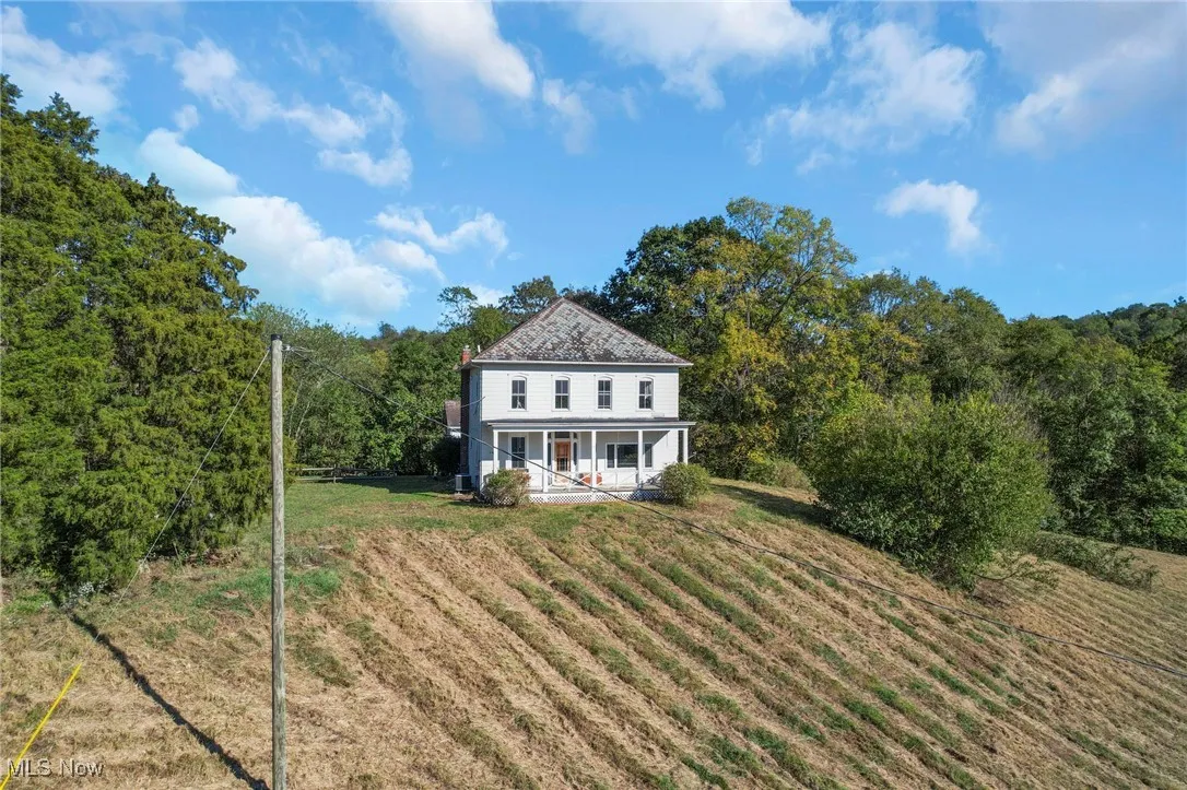 Rear view of house featuring a lawn and a porch