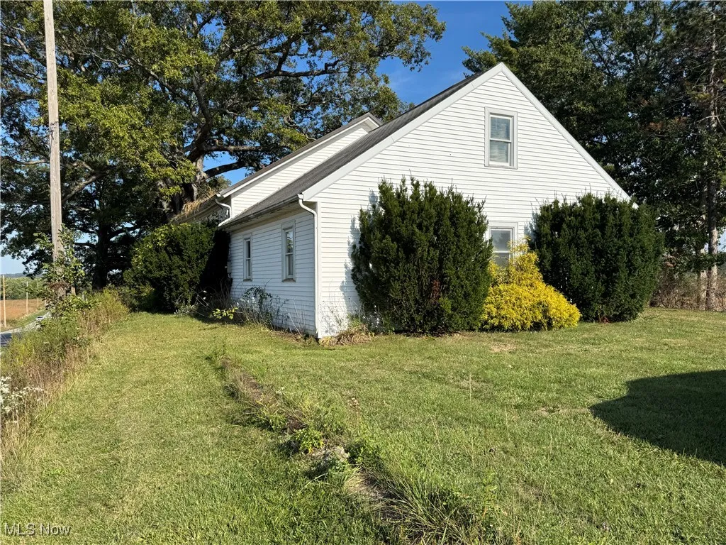View of side of home featuring a yard