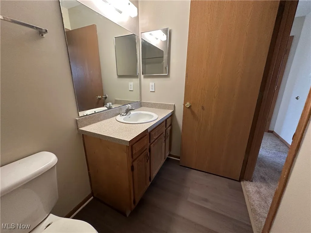 Half bath with vanity and dark wood-style floors