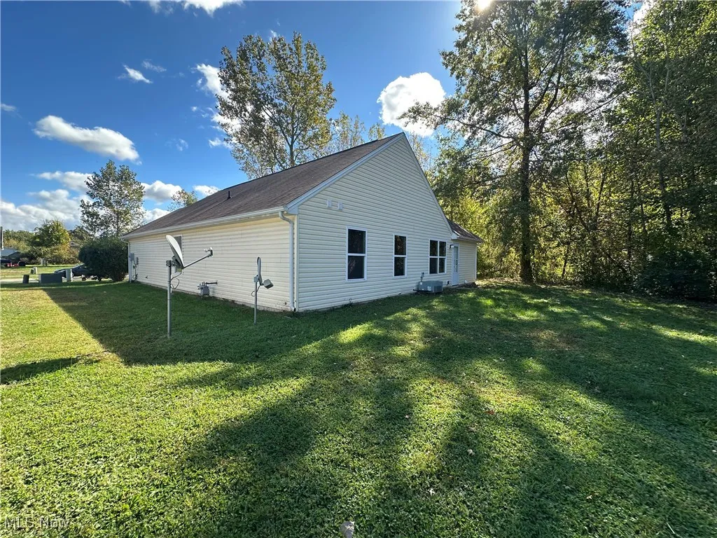 View of side of home with a yard