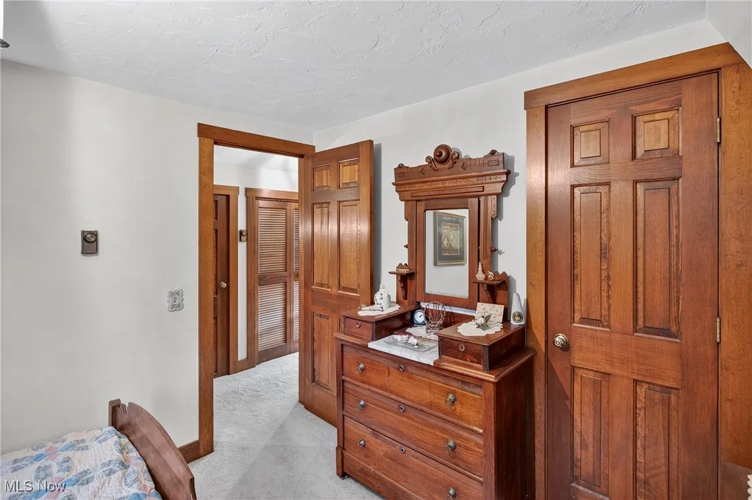 Bedroom with light colored carpet and a textured ceiling