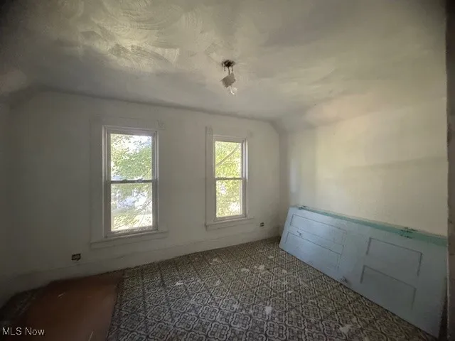 Additional living space featuring lofted ceiling and a textured ceiling