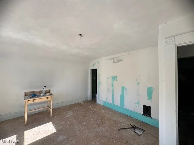 Spare room with baseboards and a textured ceiling