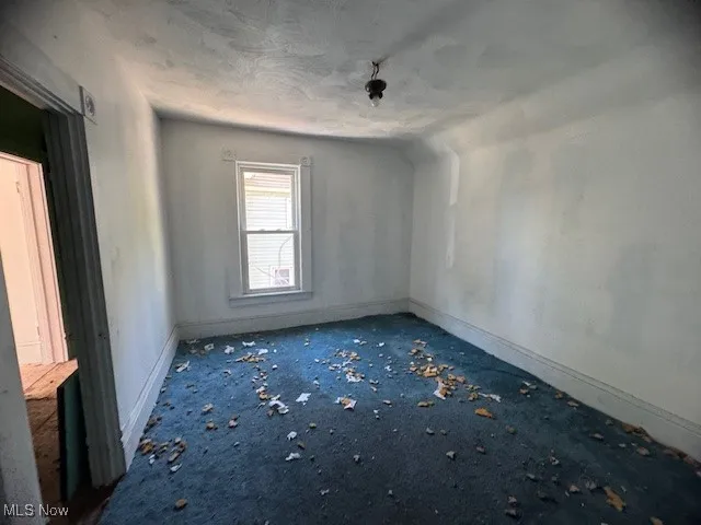 Spare room with baseboards and a textured ceiling