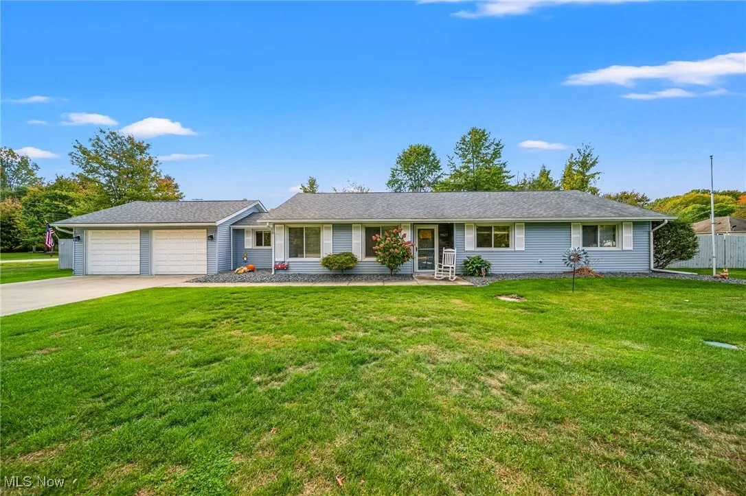 Ranch-style home with a front yard, driveway, and a garage
