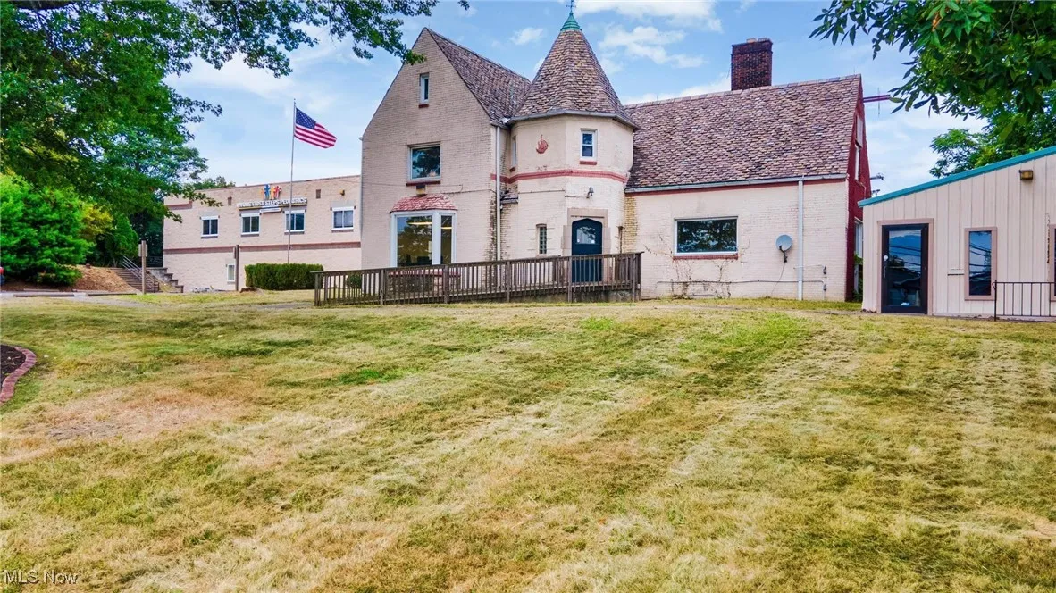 Rear view of house with a chimney and a yard